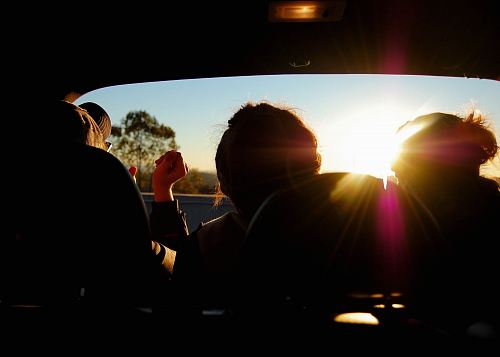 silhouette of three person inside car