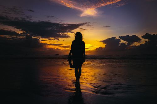 silhouette of woman standing on seashore