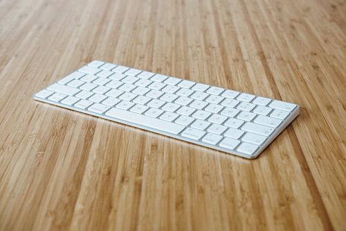 silver and white keyboard on brown wooden surface
