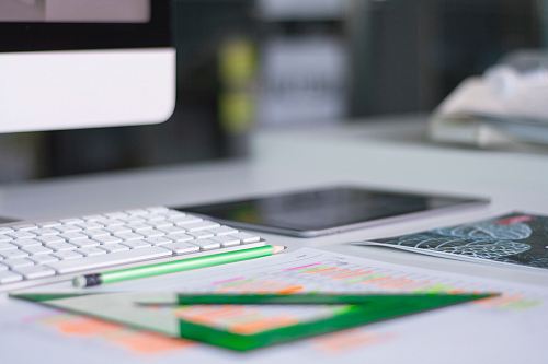 silver iMac near Magic Keyboard and green measuring tool