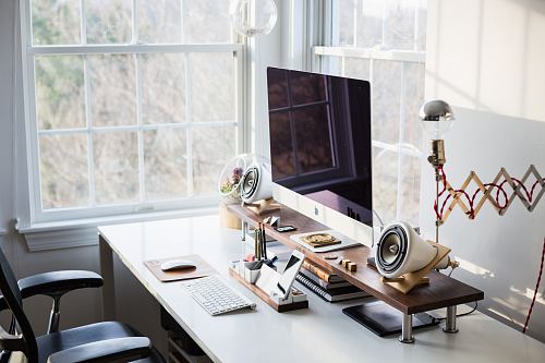 silver iMac on desk near window