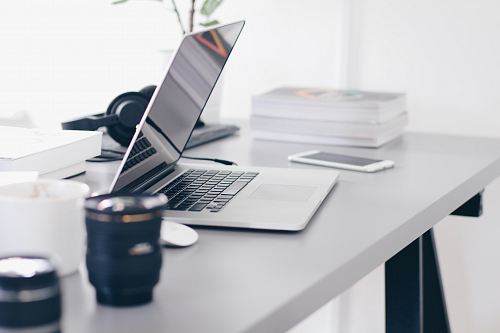 silver MacBook Pro on white table