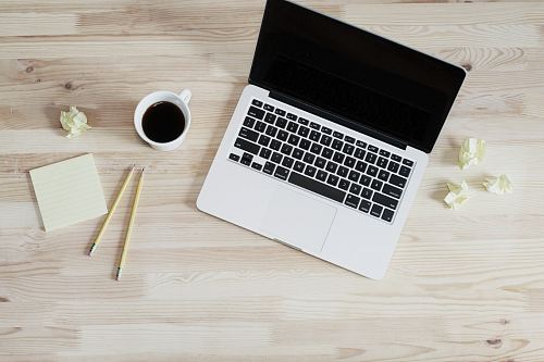 turned off MacBook Pro beside white ceramic mug filled with coffee