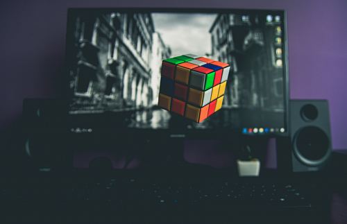 turned on flat screen computer monitor displaying 3x3 Rubik's cube