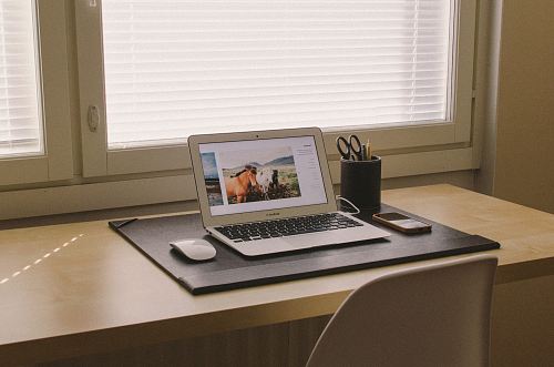 turned on MacBook on beige wooden desk