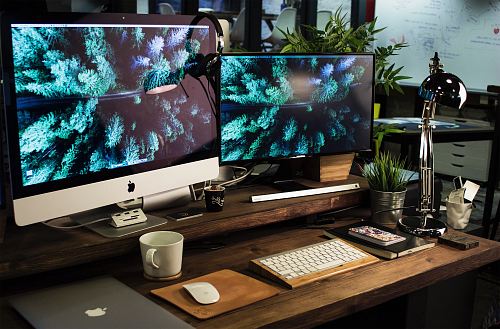 two computer monitors turned on with the same wallpaper
