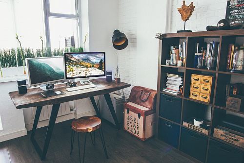 two flat screen monitor turned on near organizer rack inside the room