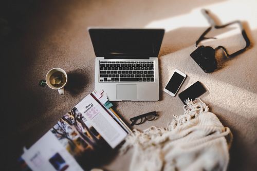 white ceramic mug near MacBook Pro