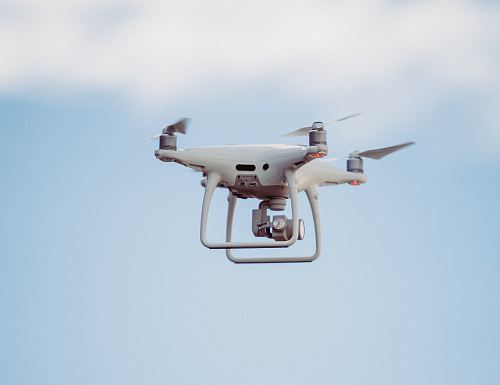 white DJI drone in mid air