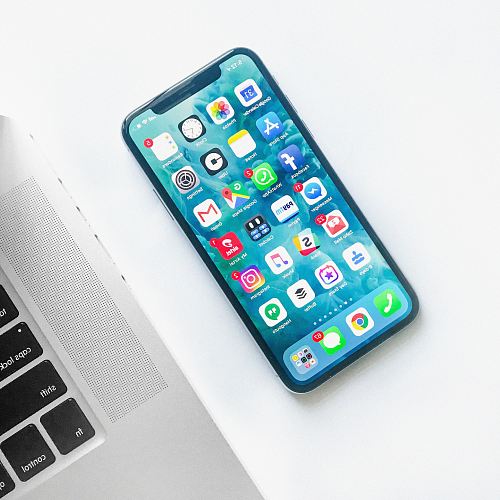 white smartphone near laptop