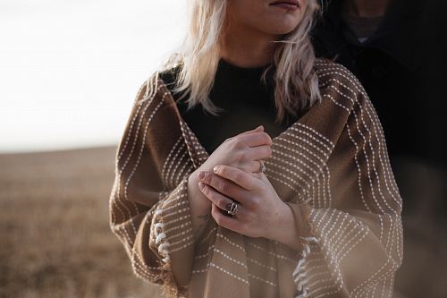 woman covered in brown scarf with cross hands