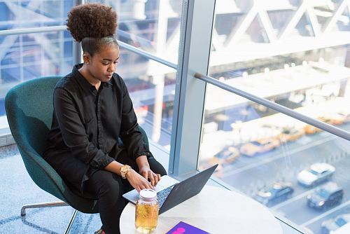 woman in black dress shirt using MacBook