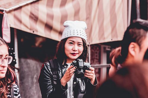 woman in black leather jacket holding DSLR camera