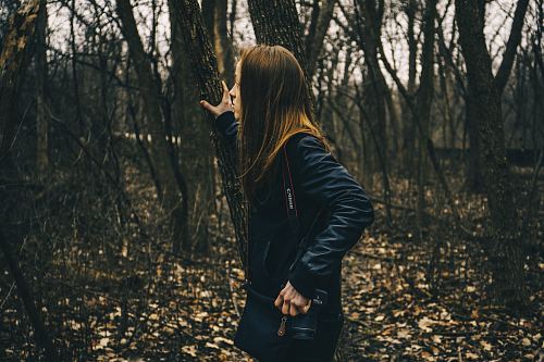 woman in forest holding tree