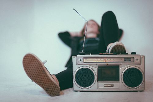 woman laying on bed near gray radio