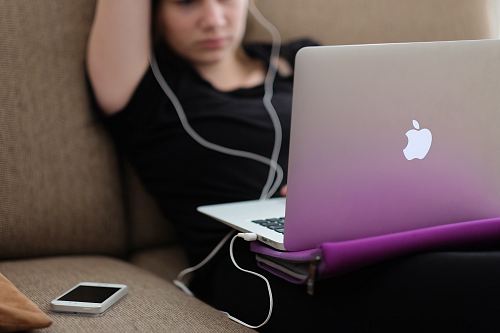 woman sitting on sofa with MacBook Air