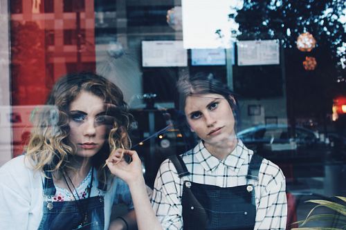 woman standing beside woman in blue dungaree