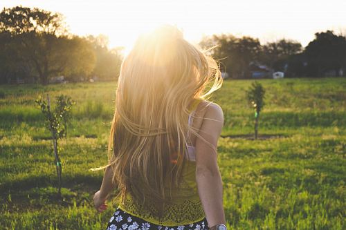 woman walking on lawn with trees