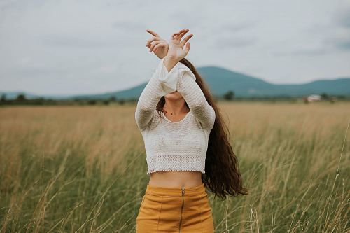 woman wearing gray crop top sweater on grass field