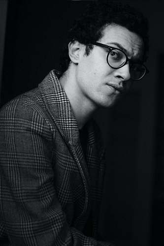  grayscale photo of man wearing suit and eyeglasses 