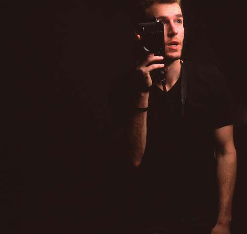 person man wearing black v-neck t-shirt holding smartphone black