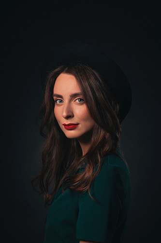 human woman in black hat and green shirt face