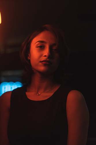 human woman in black tank top near yellow light black