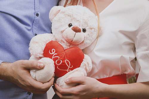  couple holding white bear plush toy 