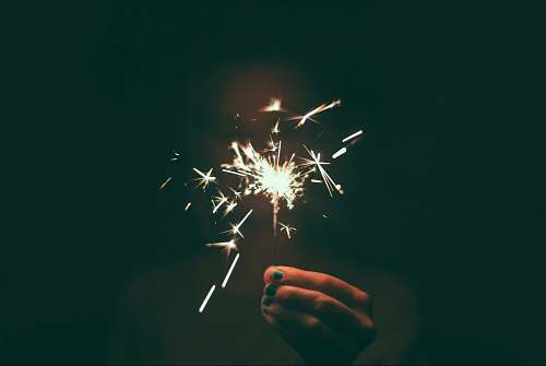  person holding lighted sparkler 