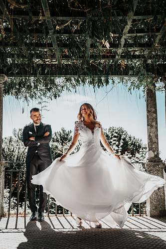 wedding woman wearing white dress beside man wearing formal suit under wooden roof during daytime clothing