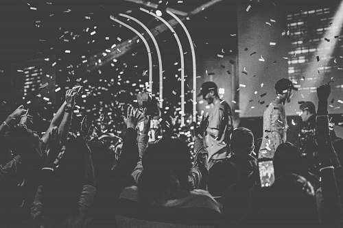 grey people performing on stage surrounded with people person