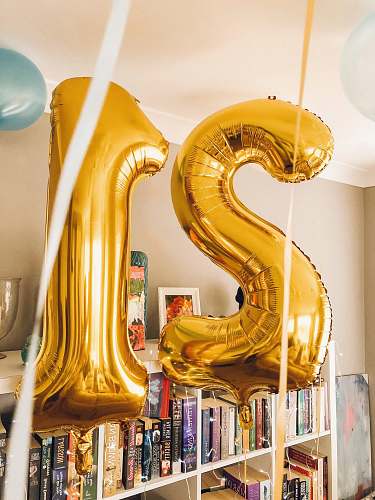 21 brass-colored 21 foil balloons inside room balloon