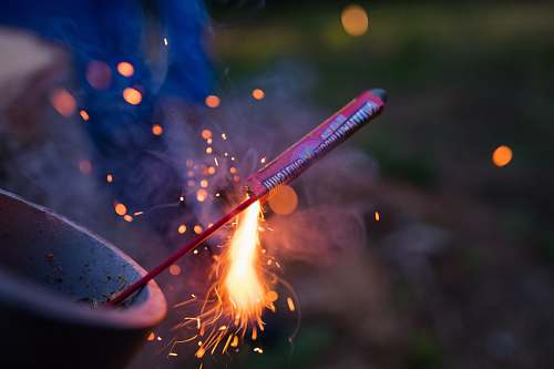 spark selective focus photography of lit firecracker bokeh