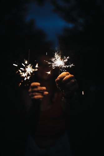 night person holding firecrackers during nighttime outdoors