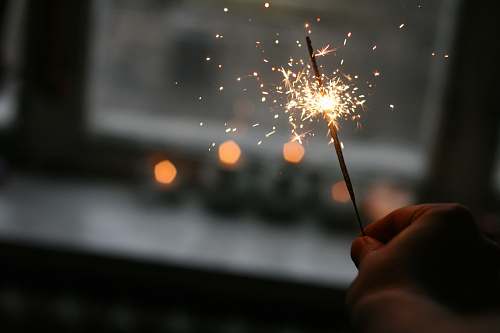 night person holding sparkler outdoors