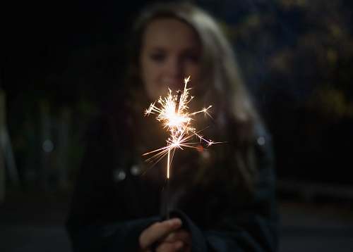 person woman holding sparkler spark