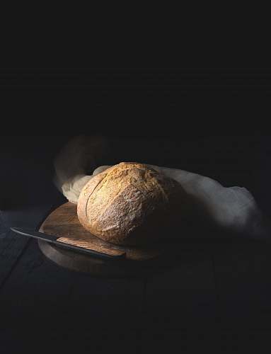 table baked bread beside knife on wooden board bread