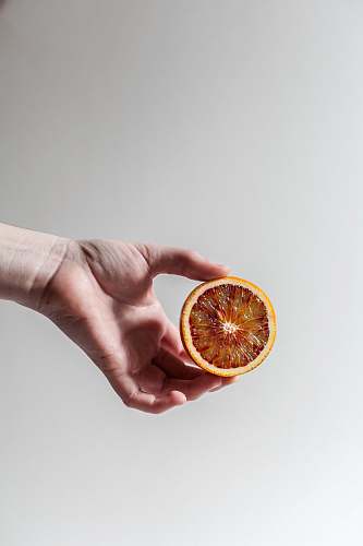 person person holding sliced grapefruit human