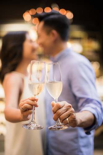 human selective focus photography of couple holding cocktail glasses person