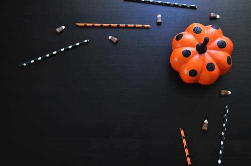 pumpkin orange and black polka-dot pumpkin toy on black table pumpkin flat lay