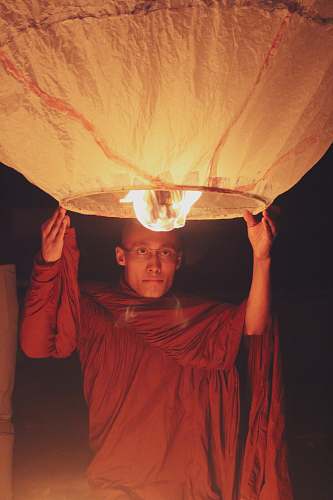 person man holding a lighted sky lantern bangladesh