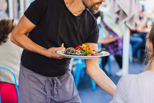 person man standing and holding plate food