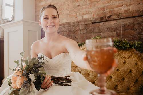 person smiling woman holding wine glass and flower bouquet plant