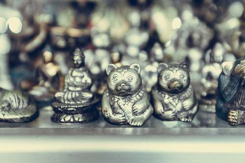 art close-up photography of silver-colored bear and Buddha figurines ubud