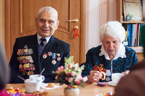 person man and woman drinking coffee in front of wooden table human