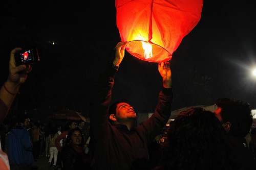human man holding lighted sky lantern lantern