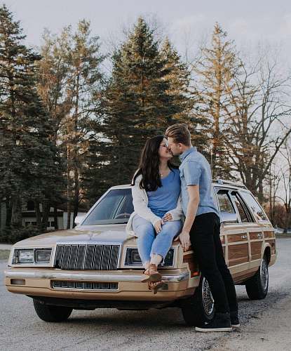 human man kissing woman while sitting on brown car people