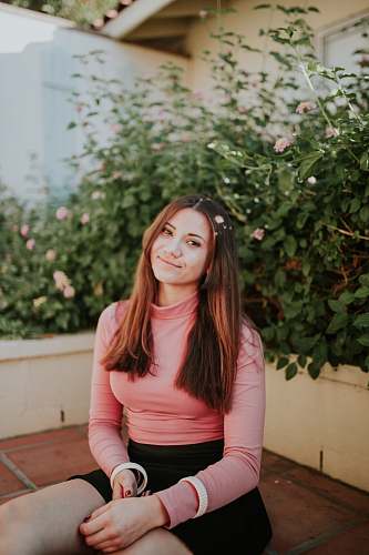 people woman sitting near pink flowers at daytime plant