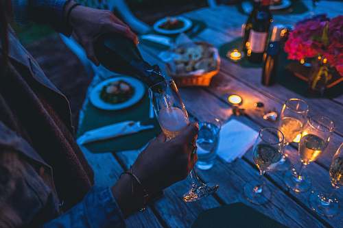 glass person putting wine on flute glass party