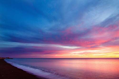 sky body of water and seashore beach